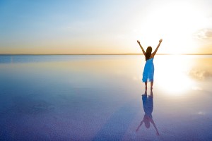 Silhouette of a woman with her arms raised to the sun